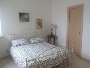 a bedroom with a bed with a white comforter at Attico Ostuni in Ostuni