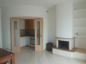 a kitchen with a door open to a room with a fireplace at Attico Ostuni in Ostuni
