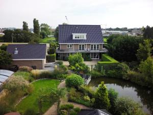 an aerial view of a house with a pond at Harlingen Garden Apartment in Midlum