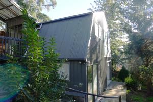 a house with a green roof and a staircase at Moon House in Diamond Creek