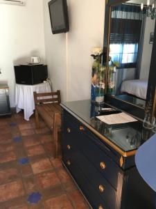 a room with a dresser and a mirror at La Hacienda del Marquesado in Albuñán