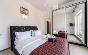 sypialnia z dużym łóżkiem i dużym lustrem w obiekcie Hotel Sorrento w Odessie