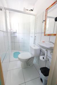 a white bathroom with a toilet and a sink at Natural Do Rio Guesthouse in Rio de Janeiro