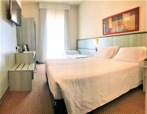 a hotel room with a large bed and a window at Hotel Principe di Piemonte in Rimini