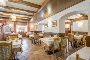 a restaurant with tables and chairs in a room at Al Pian Garnì Hotel - B&B & Pizza in Vattaro