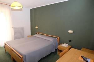 sypialnia z łóżkiem i drewnianym stołem w obiekcie Al Pian Garnì Hotel - B&B & Pizza w mieście Vattaro