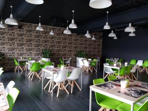 a restaurant with tables and chairs and a brick wall at Hotel O Ieper in Ieper