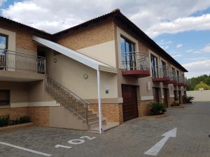 un edificio con escaleras y balcones en un aparcamiento en Europrime Hotel en Boksburg