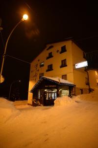 a building in the snow at night with a street light at Hotel Belvedere in Roccaraso