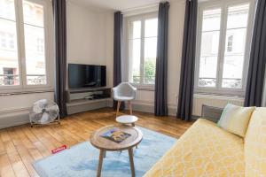 een woonkamer met een bank en een tafel bij Suite Rimbaud in Charleville-Mézières