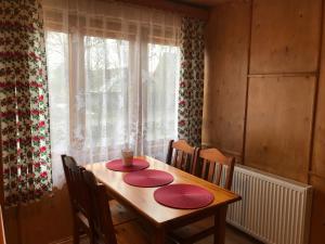 una mesa de madera con dos placas rojas. en Apartament Widok, en Czarna Góra