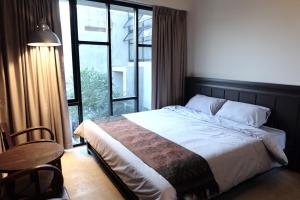 a bedroom with a bed and a large window at Antique Chiangmai in Chiang Mai