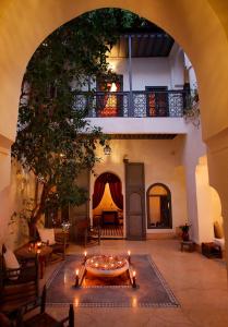 une cour avec une table et des bougies dans un bâtiment dans l'établissement Dar Touyir, à Marrakech