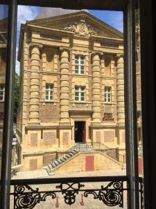 een raam met uitzicht op een gebouw bij Suite Rimbaud in Charleville-Mézières