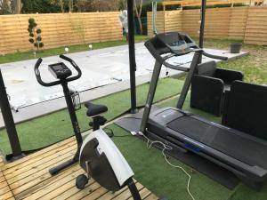 a gym with a treadmill and a tv on a deck at L'Atelier Zen in Sarreguemines