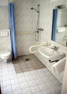 La salle de bains est pourvue d'un lavabo, d'une douche et de toilettes. dans l'établissement Landhotel Pagram-Frankfurt/Oder, à Francfort-sur-l'Oder