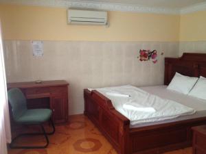 a bedroom with a bed and a desk and a chair at 139 Guest House in Phnom Penh