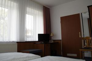 een hotelkamer met een bed en een bureau met een computer bij Landhotel Pagram-Frankfurt/Oder in Frankfurt/Oder