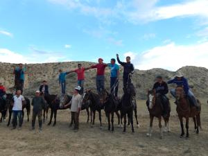 a group of people standing on horses in the desert at Jurten Camp Almaluu in Tong