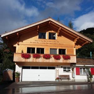 un edificio con un balcón con flores. en Bunderbach, en Adelboden