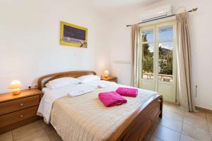 a bedroom with a bed with two pillows on it at Villa San Dimitrio House on the Beach in Logaras