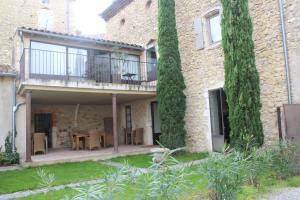 a house with a balcony and a table and chairs at Hôtel de Mirmande in Mirmande