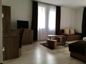 ein Wohnzimmer mit einem Sofa und einem Tisch in der Unterkunft M&F Apartman in Egerszalók