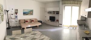 a white living room with a couch and a television at Lambretta's Home in Milan