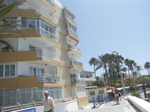 un hombre parado frente a un edificio alto en Apartamentos Lual Torrecilla, en Nerja