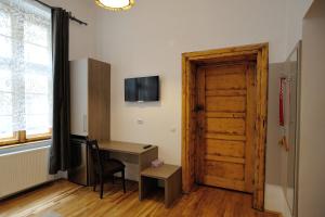 een kamer met een houten deur, een bureau en een raam bij Dinicu Residence - Central Location in Braşov
