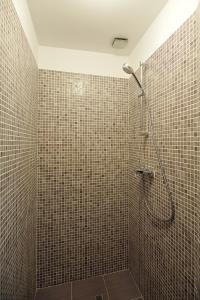a bathroom with a shower with brown tiled walls at Dinicu Residence - Central Location in Braşov