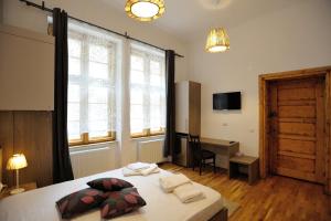 a bedroom with a bed and a desk and a window at Dinicu Residence - Central Location in Braşov
