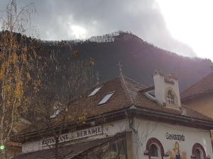 a building with a church with a mountain in the background at Dinicu Residence - Central Location in Braşov
