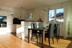 eine Küche und ein Esszimmer mit einem Tisch und Stühlen in der Unterkunft Blumenau in Davos