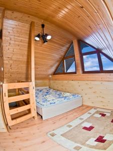 een slaapkamer in een blokhut met een bed en ramen bij Penzion u Šeliho in Veľká Lomnica