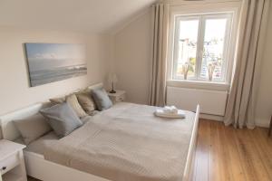 een witte slaapkamer met een groot bed en een raam bij Apartment Stadtblick in Lübeck