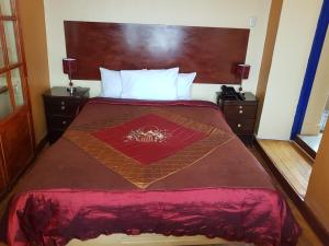 
a bedroom with a bed and a dresser at Kurumi Hostel in Cusco
