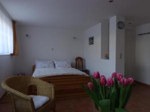 Schlafzimmer mit einem Bett und einem Strauß rosa Tulpen in der Unterkunft Weimar-Appartement in Weimar