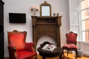 a living room with a fireplace and two chairs at Heart of Pamplona Apartments IV in Pamplona