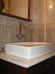 Un lavabo blanco en un baño con espejo. en Planinski Biser, en Kopaonik