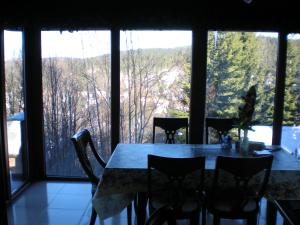 una mesa y sillas en una habitación con ventanas grandes en Planinski Biser, en Kopaonik 49 fotos más