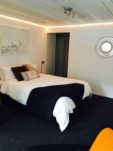 a bedroom with a large bed with black and white sheets at Modern Wall in Cambridge