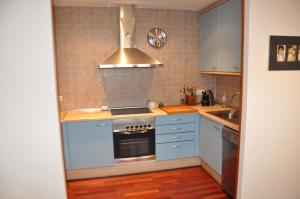 a kitchen with blue cabinets and a stove top oven at Casa en la Molina in La Molina