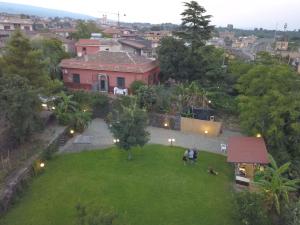 un grupo de personas sentadas en un jardín en un patio en B&B Villa Lidia, en Acireale