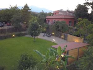 アチレアーレにあるB&B Villa Lidiaのピンクの建物と家のある庭の景色