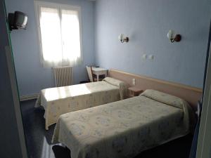 Giường trong phòng chung tại Hôtel Hélios