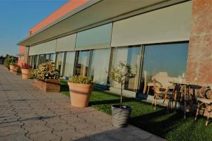 - un bâtiment avec de grandes fenêtres, une table et des chaises dans l'établissement Quinta do Louredo Hotel, à Espinhel