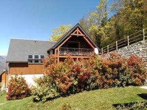 a house with a stone wall next to a yard at Les GITES DE CAMPARAN - gîte "le PETIT CHALET" in Camparan