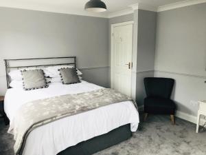 a bedroom with a bed and a blue chair at Olcote House in Padstow +7 photos