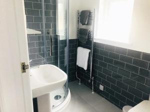 a blue tiled bathroom with a sink and a shower at Olcote House in Padstow